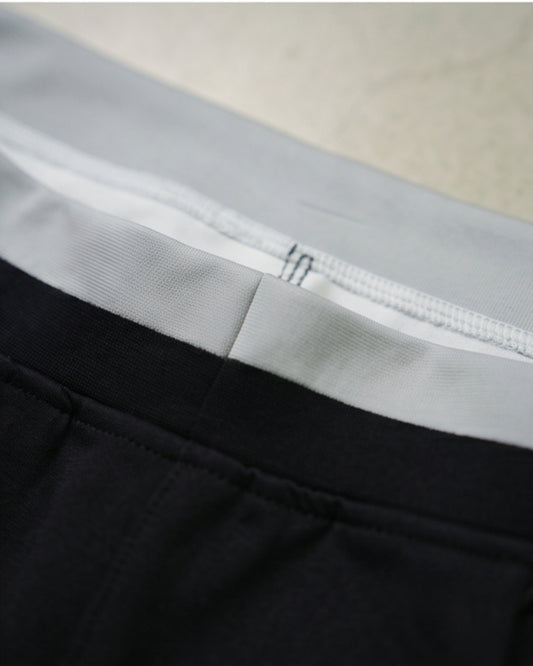 Black and white men's athletic track pants with four-way stretch.